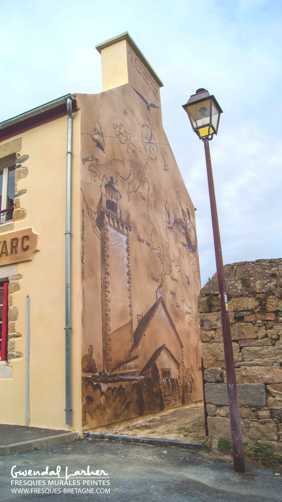 Détail vertical d'un lampadaire peint en trompe-l'œil sur le pignon de la maison « À Jeanne d'Arc » à Locquénolé